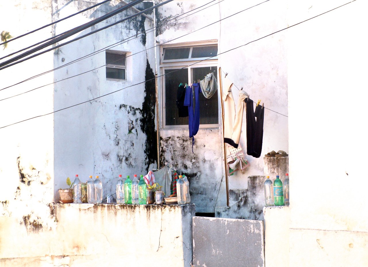 drying rack with clothes hung next to wall with windows