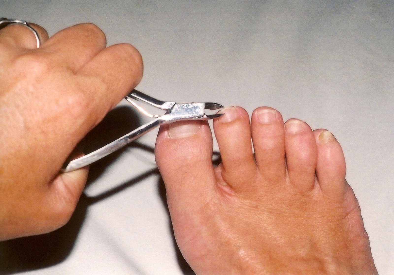 a woman is trimming the toe of a pair of scissors