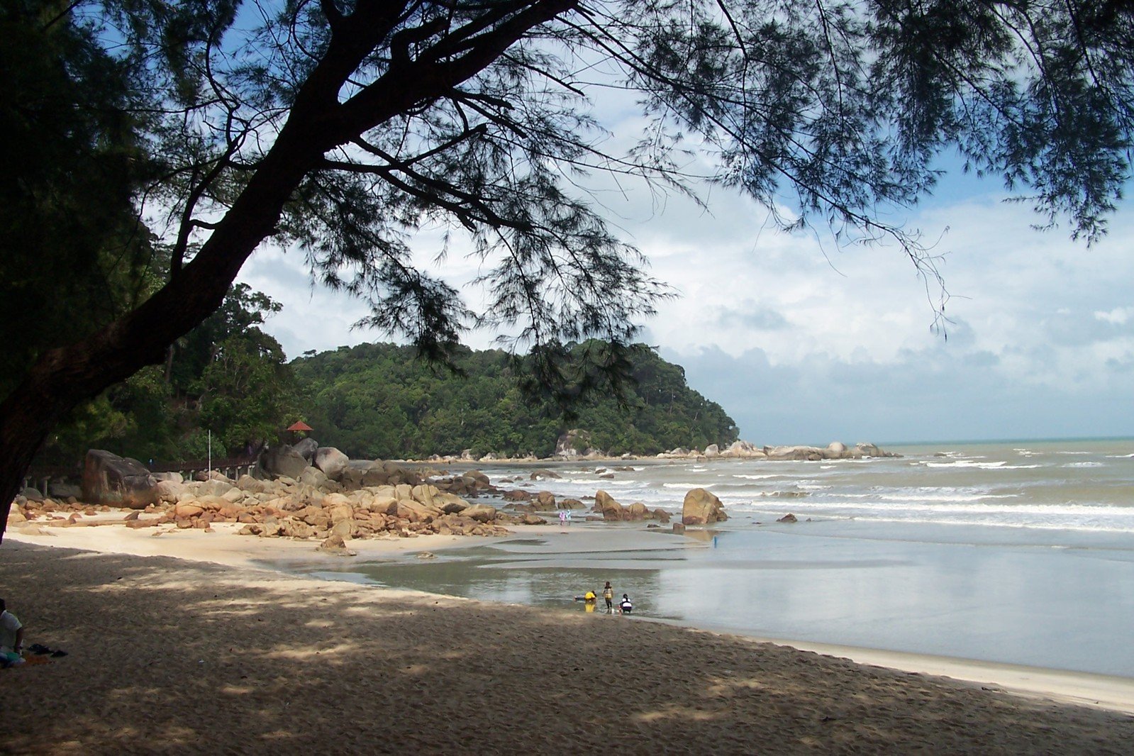 a person laying on the beach near water