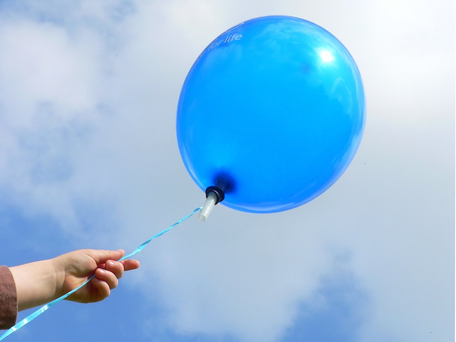 the blue balloon is being released by someone