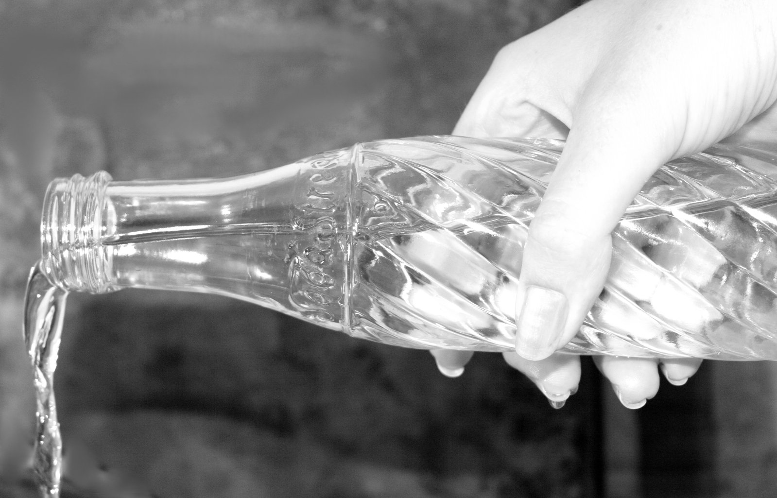 a hand holding a empty glass jar full of water