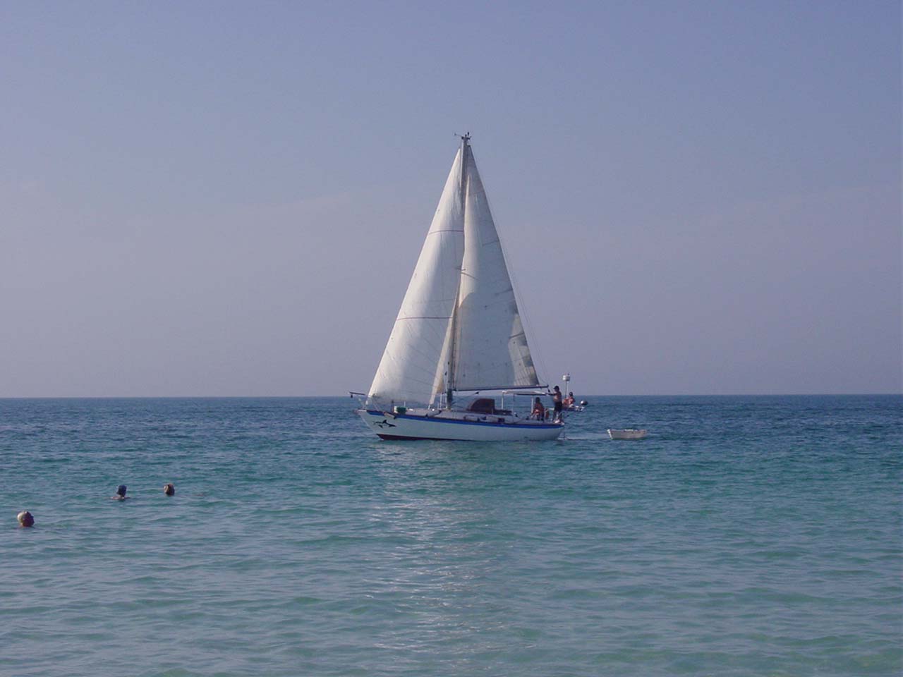 there is a sailboat with white sails in the water
