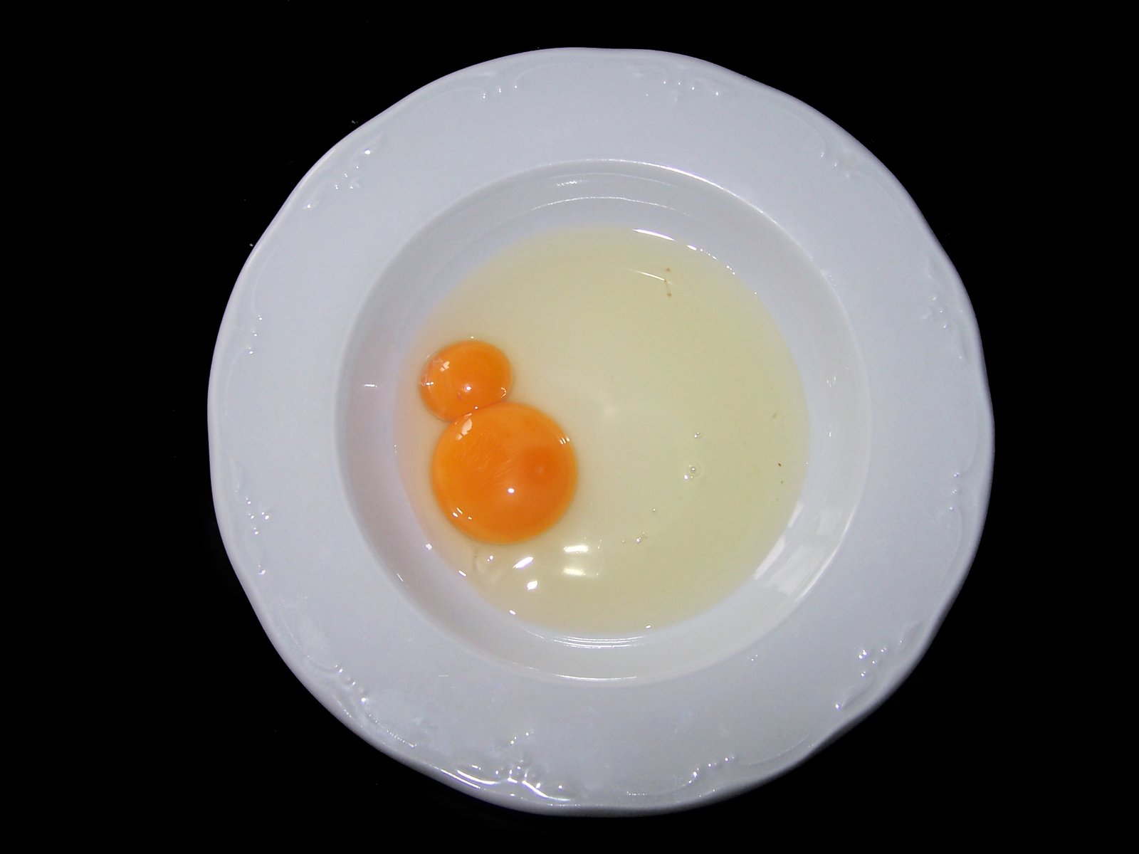 two eggs in a bowl with some sort of thing inside