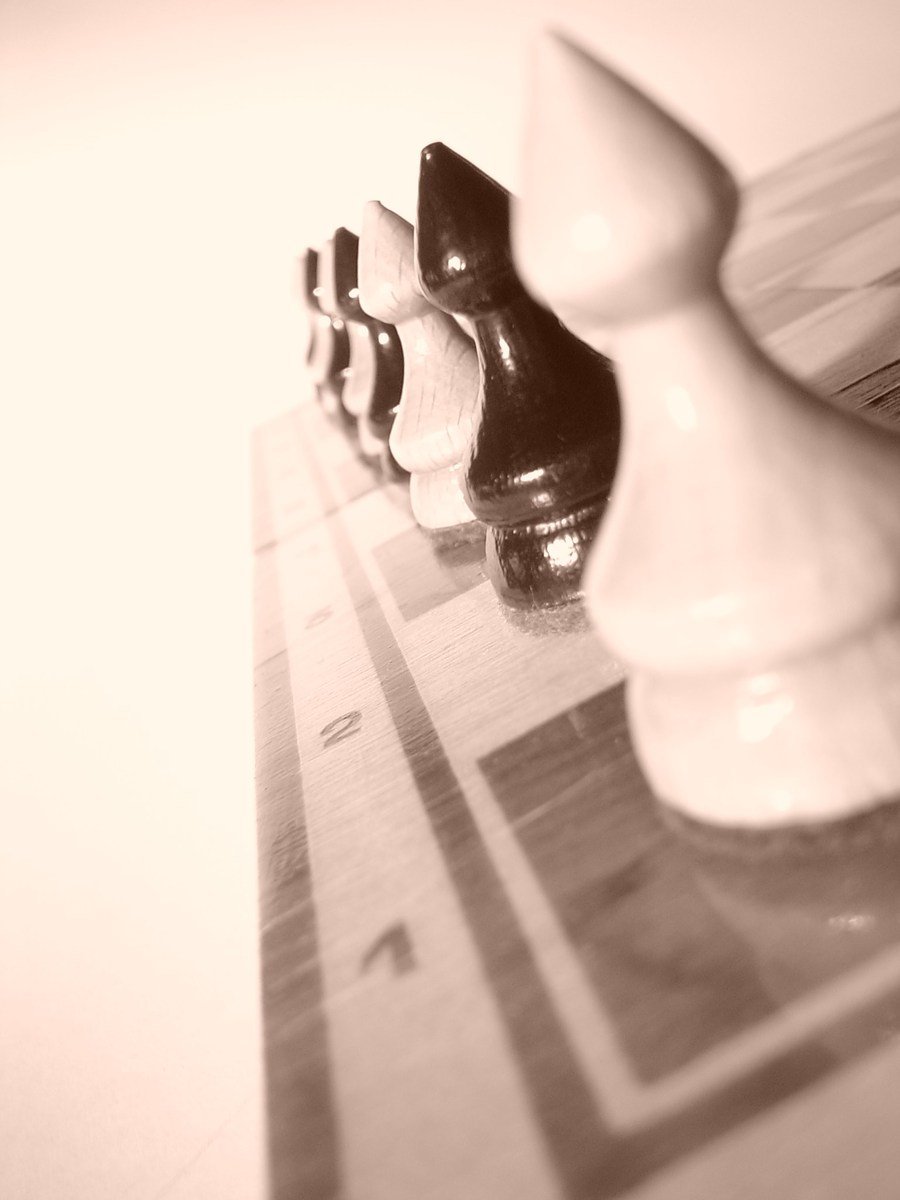 a group of pawn pieces sitting on top of a checkered counter
