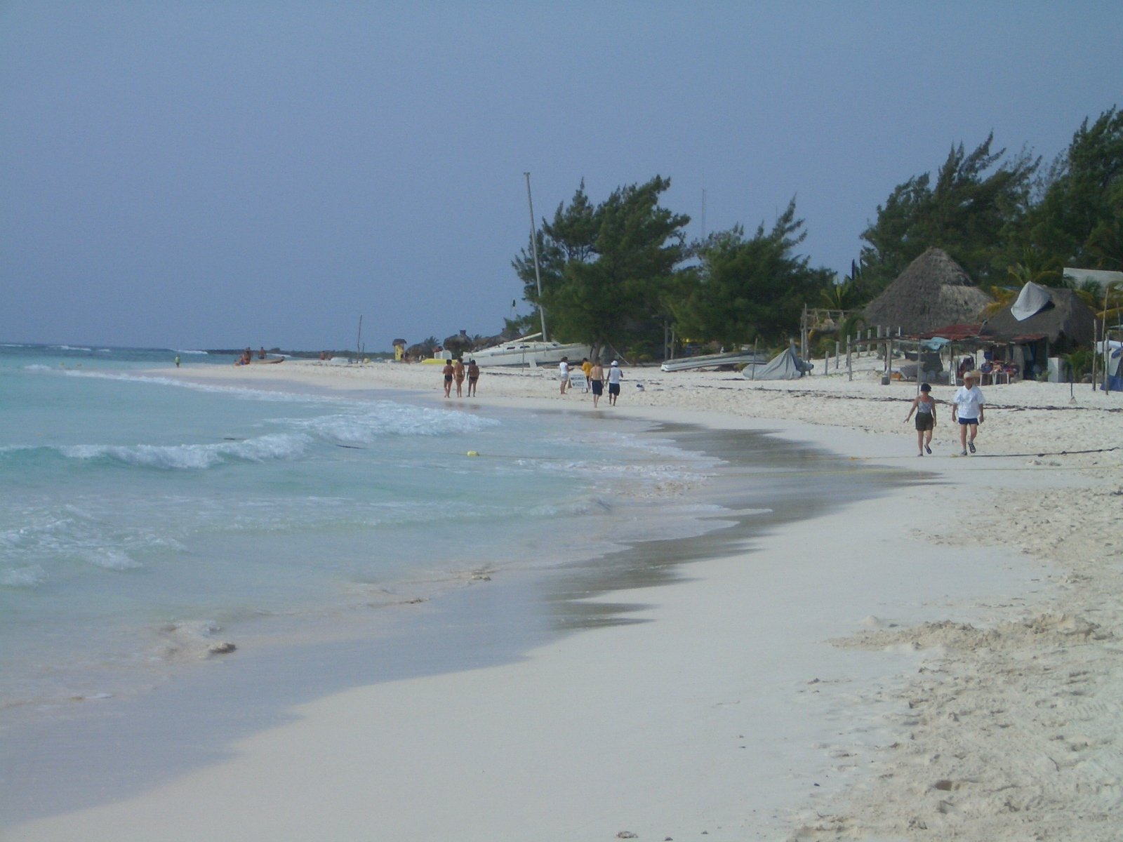 a beach that has people walking on it