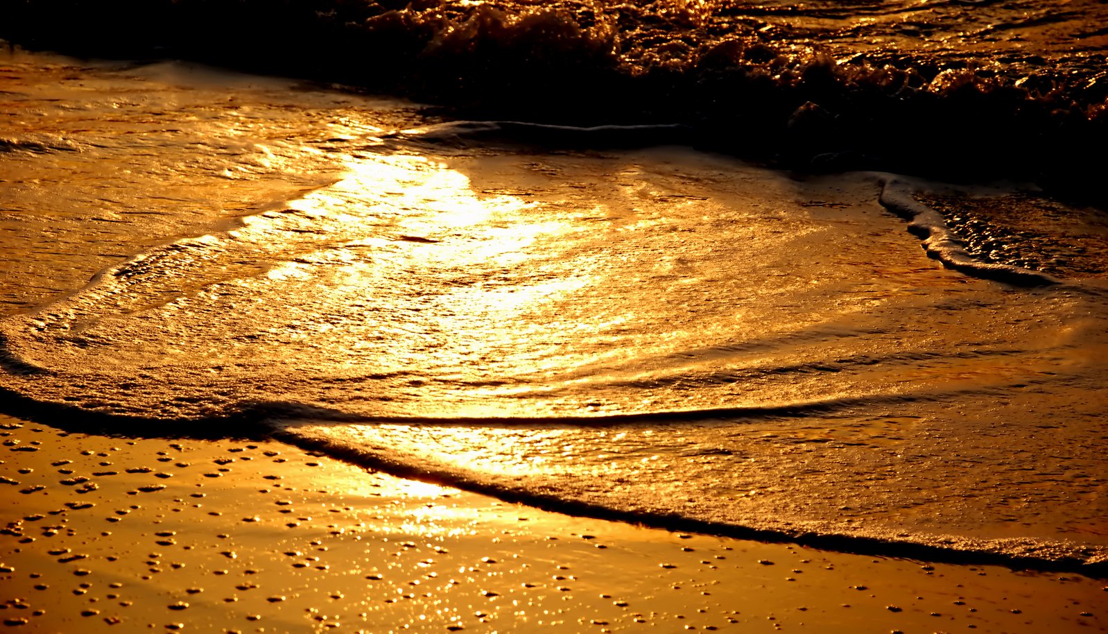 the tide is moving towards the shore at sunset