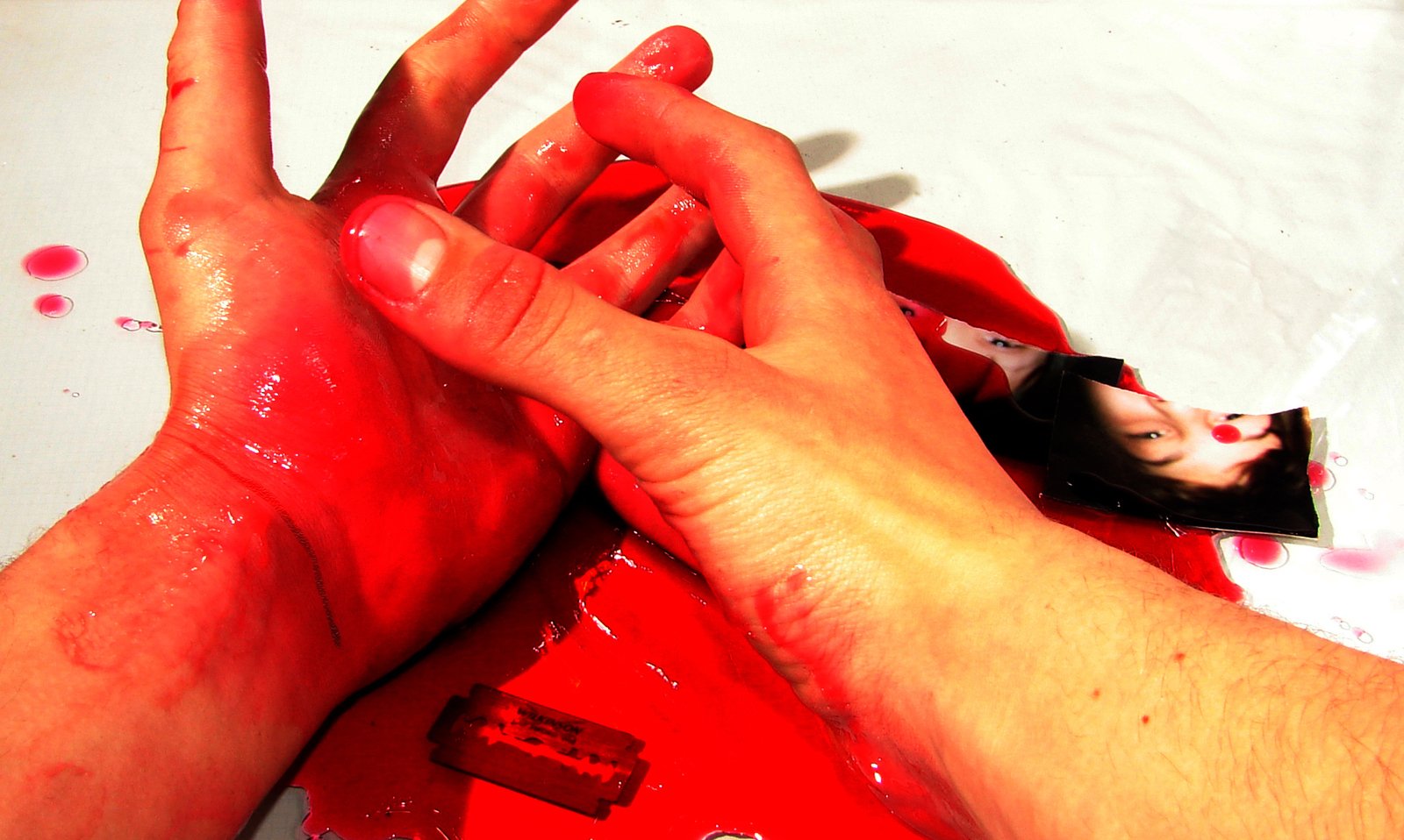 two persons'hands covered in red paint