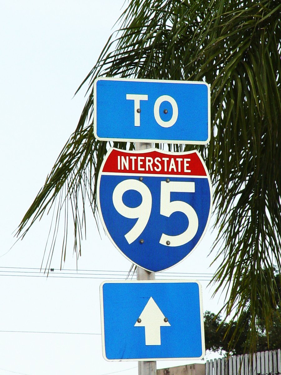 a close up of a street sign with tree in the background