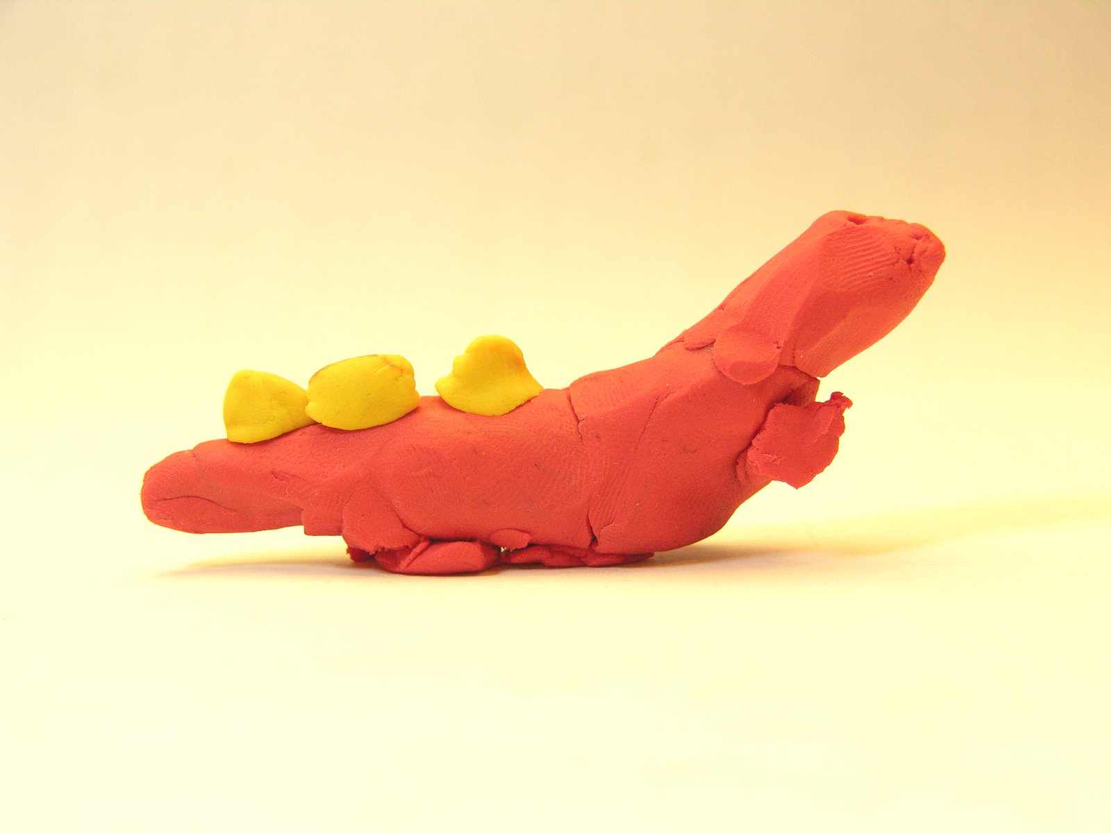 the toy alligator with two birds sits on a white background