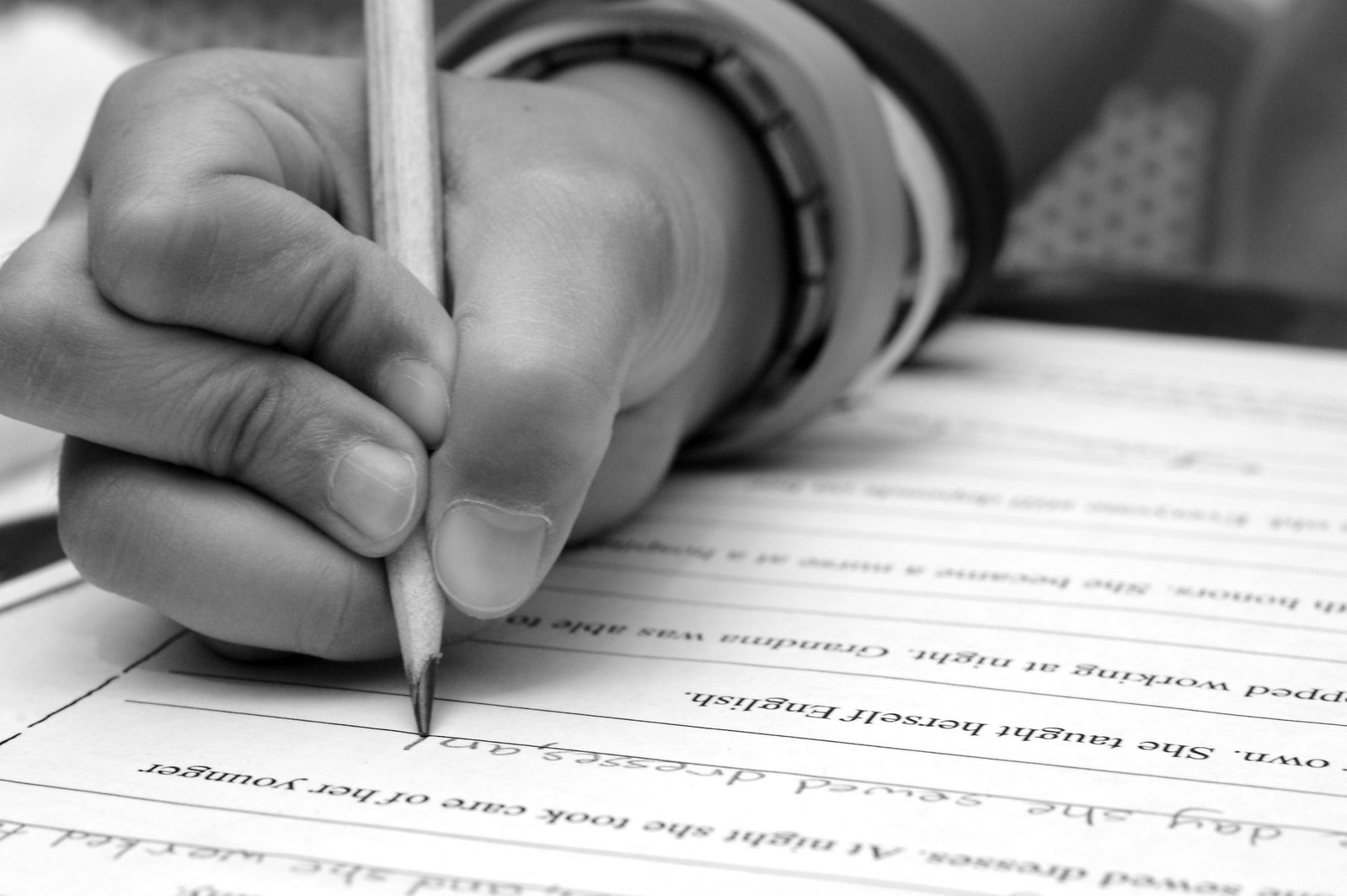 black and white image of a person writing on a paper