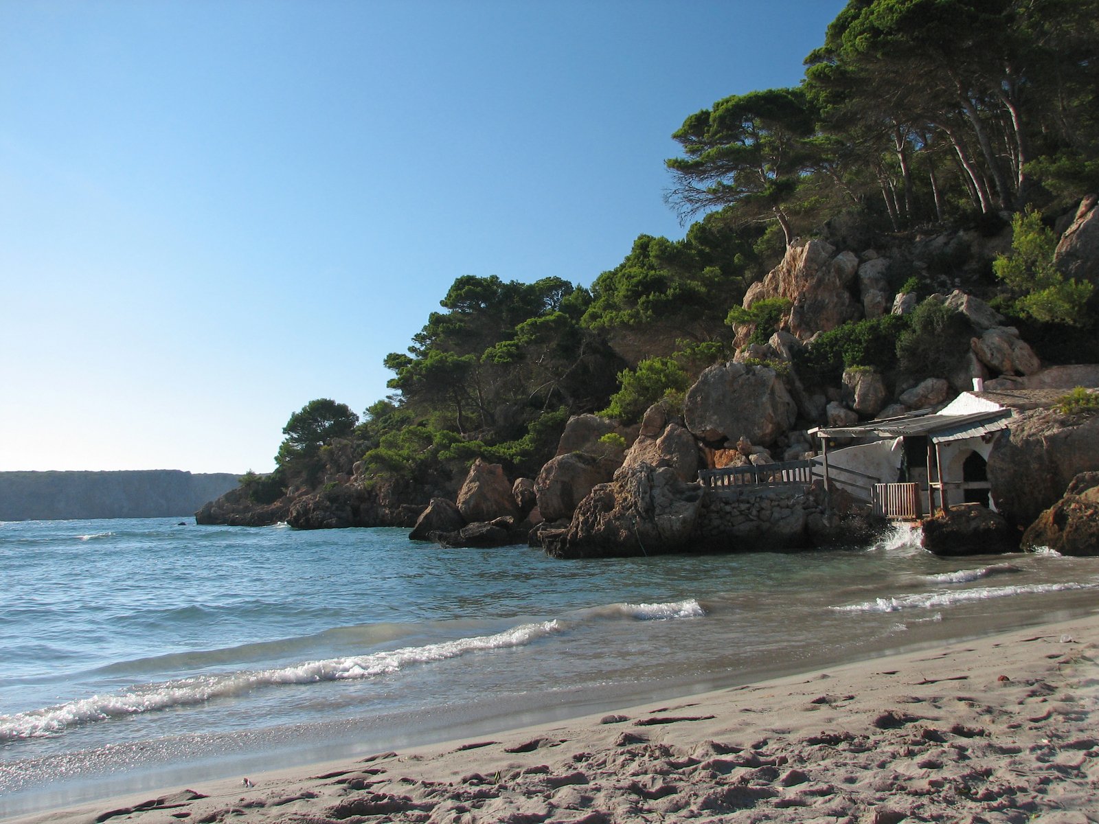 people are on the beach as well as several rocks