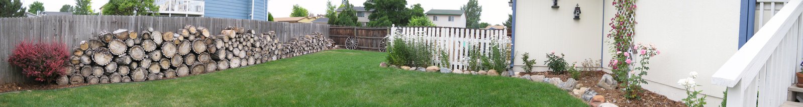 the backyard has wooden fencing and green lawn