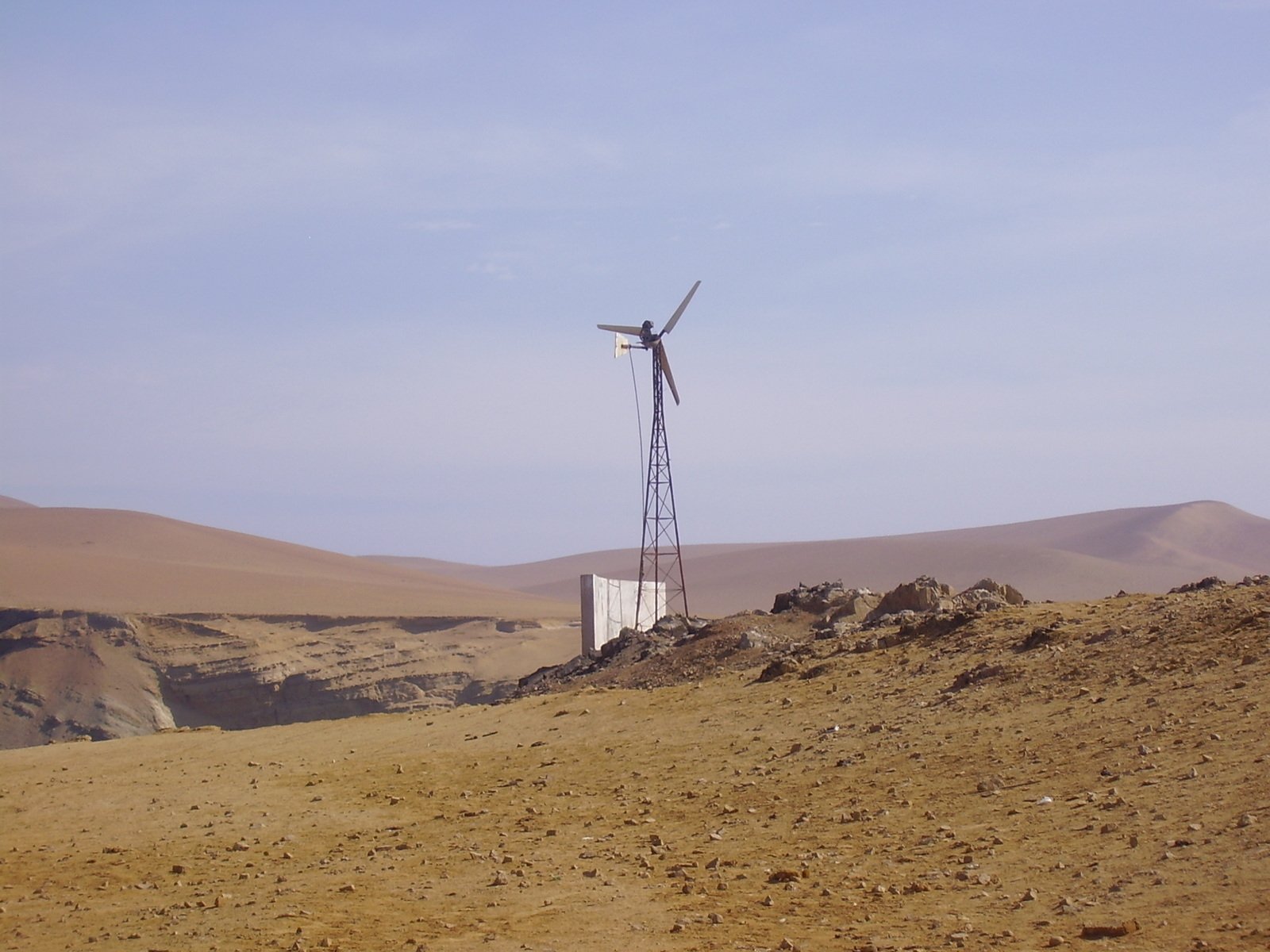 a windmill is on top of a sand hill