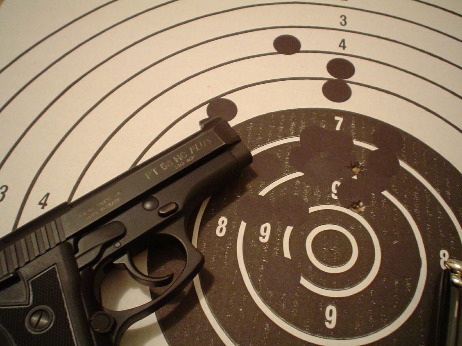 a handgun on a bulls eye with arrows and points on the board