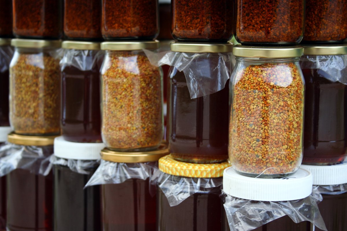 many jars of canned food are covered with clear plastic