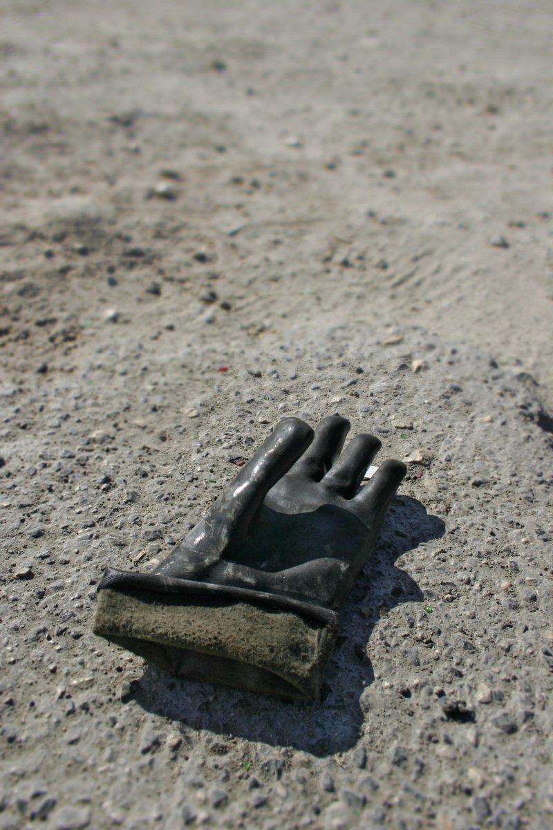 a piece of rubber sitting on the road with dirt