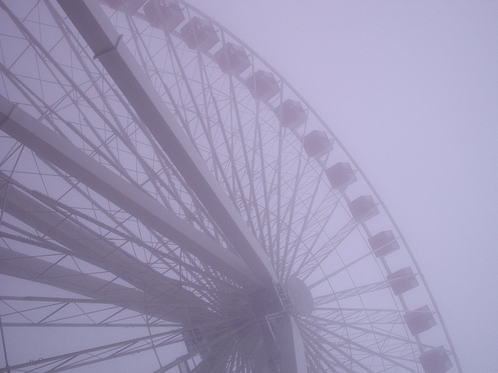 a large ferris wheel on a foggy day