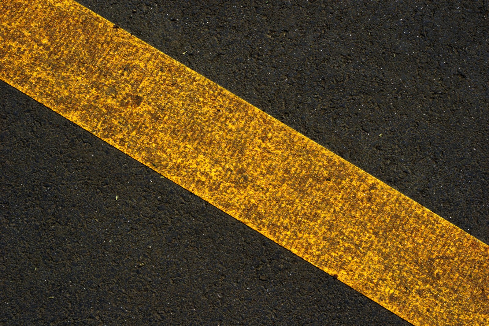 an image of a yellow striped line painted on the road