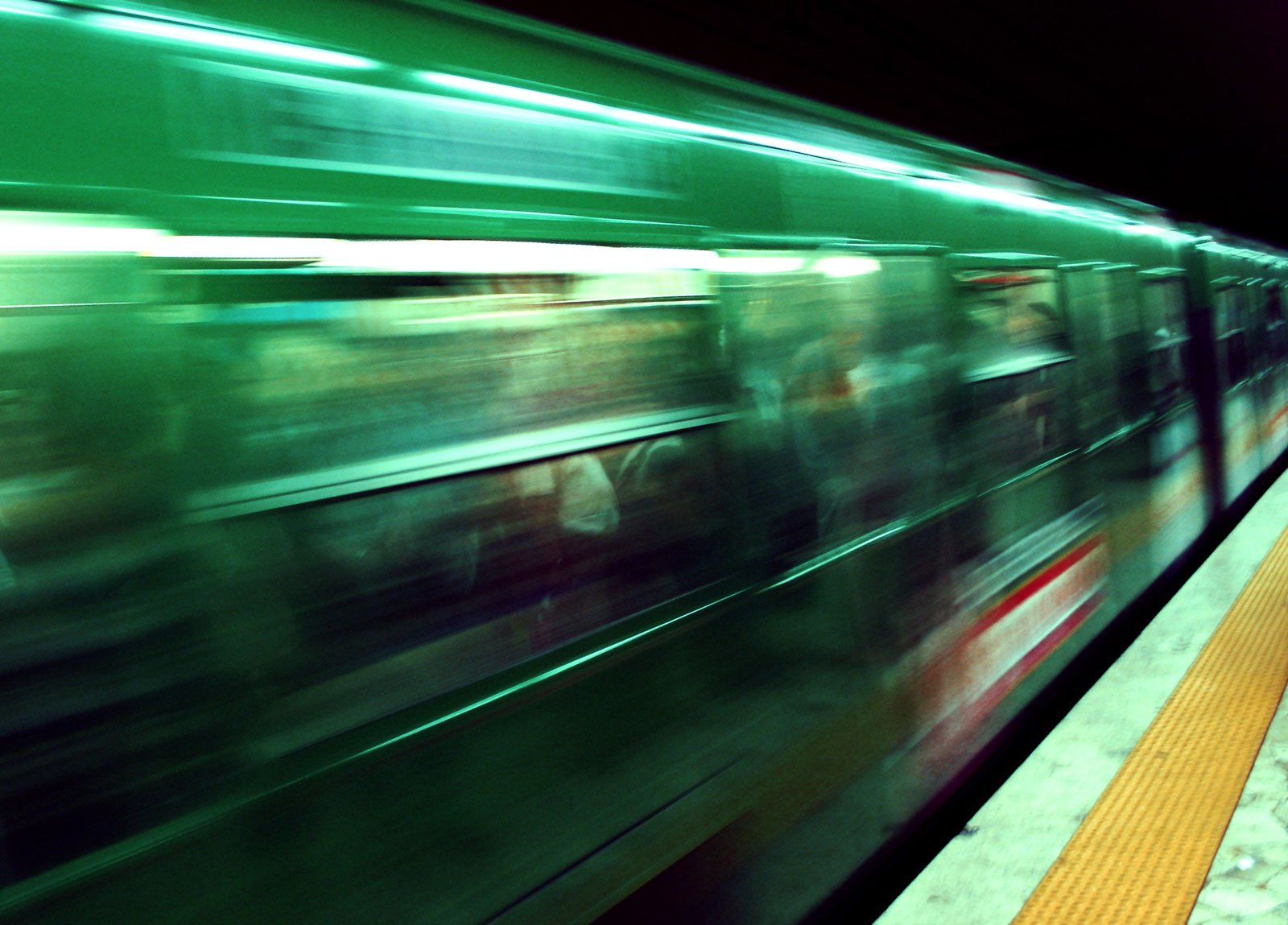 people are riding on a subway train near a platform