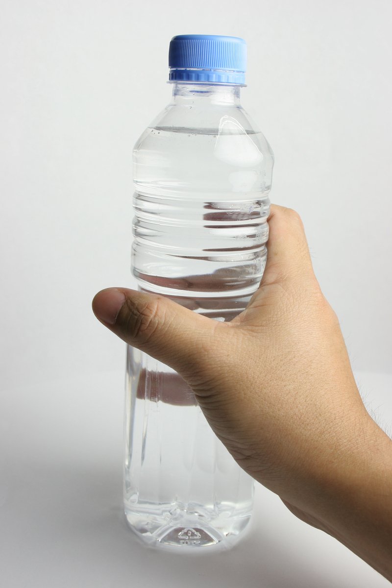 a person holding a bottled water bottle in their hand