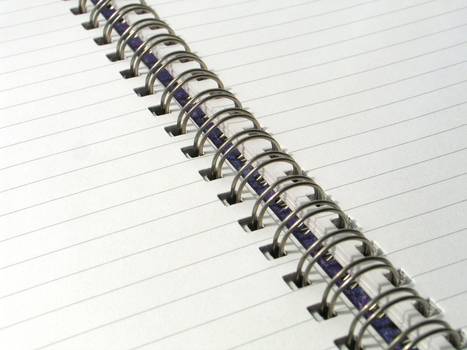 a lined up notebook with lots of black pins