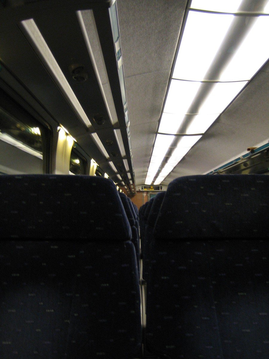 the back side of two blue seats on a train