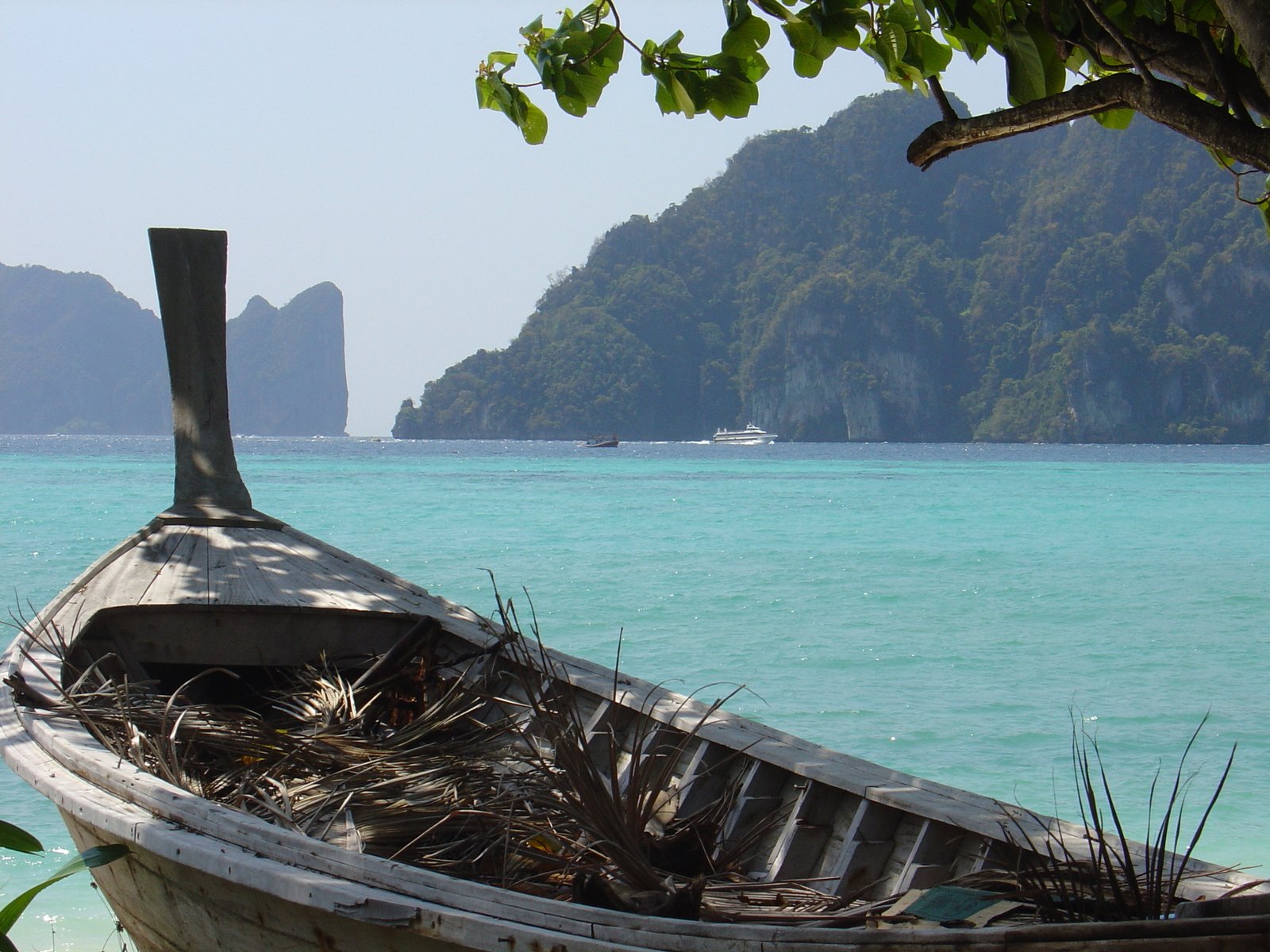 a boat sits alone on the shore of an ocean