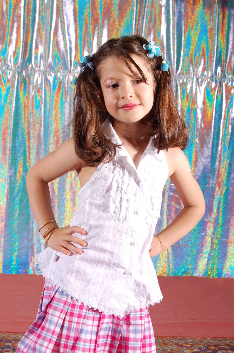 a small girl is posing in her school clothes