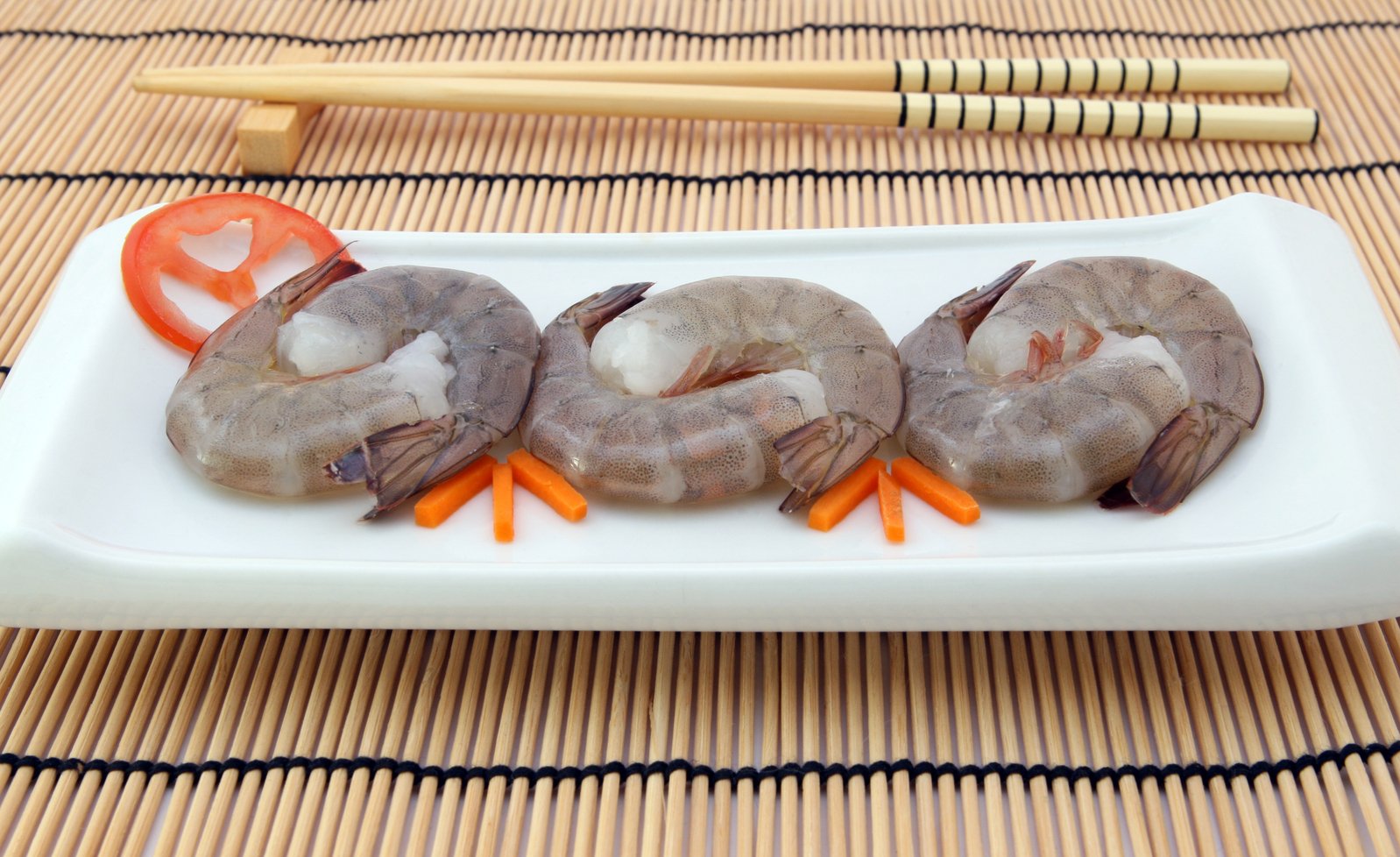 this plate contains shrimp and carrots with chopsticks