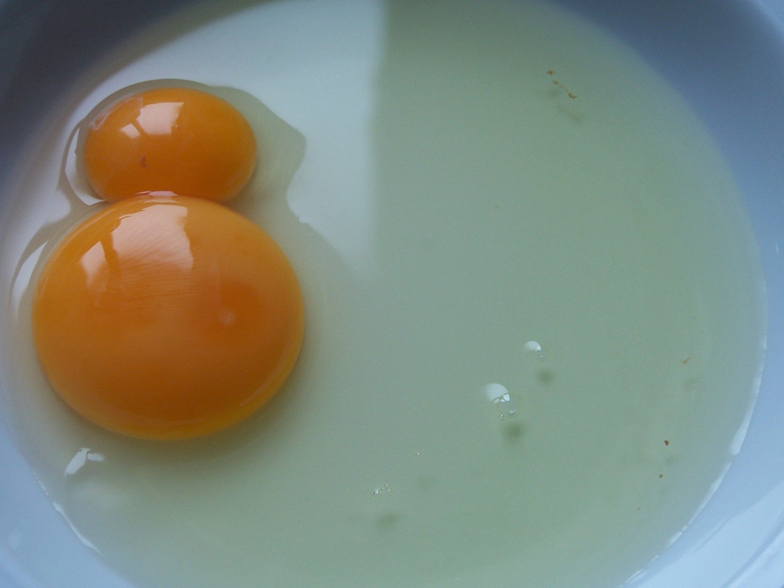 two eggs are in a bowl with cream
