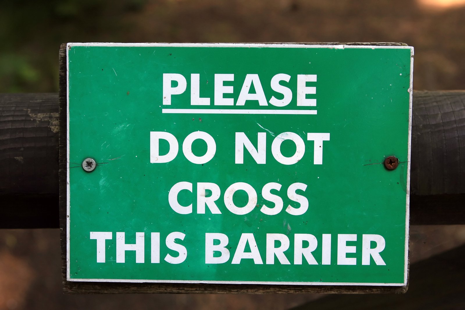 this sign says please do not cross this barrier