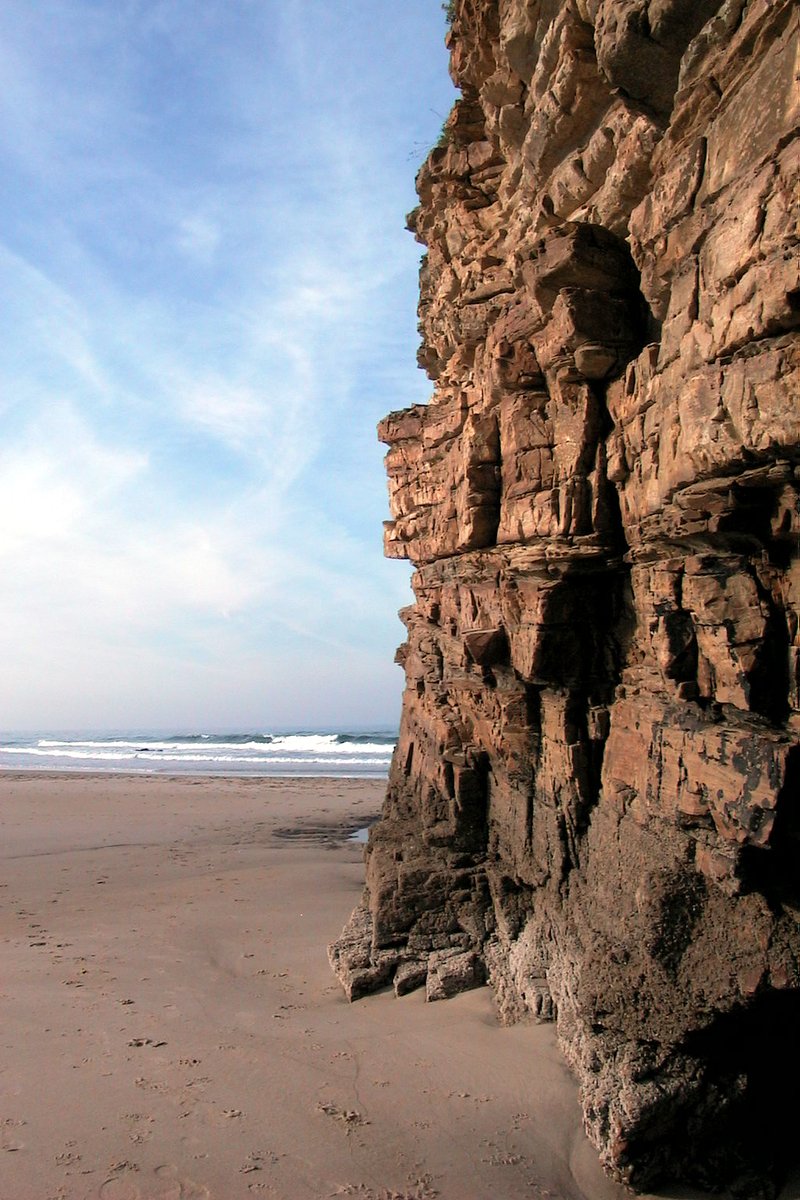 rocks at the end of the ocean with a sky background