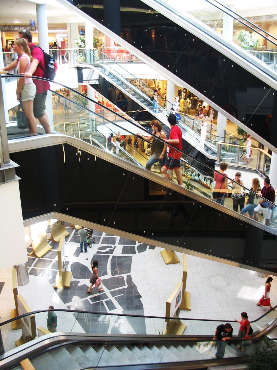 people riding on the escalators in a shopping mall