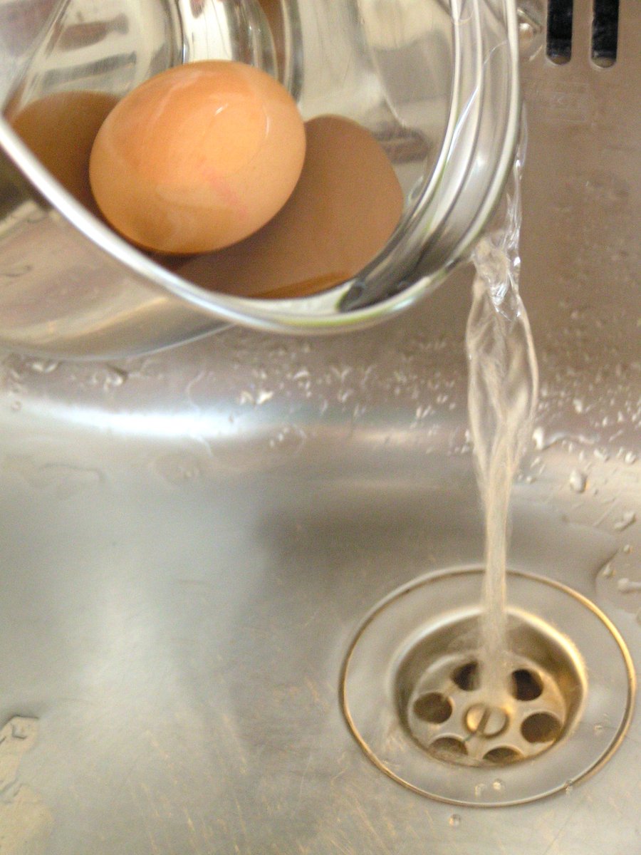 a liquid poured into a metal sink with eggs inside