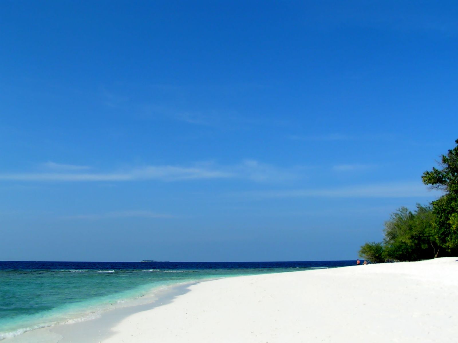 a sandy beach with clear blue ocean water