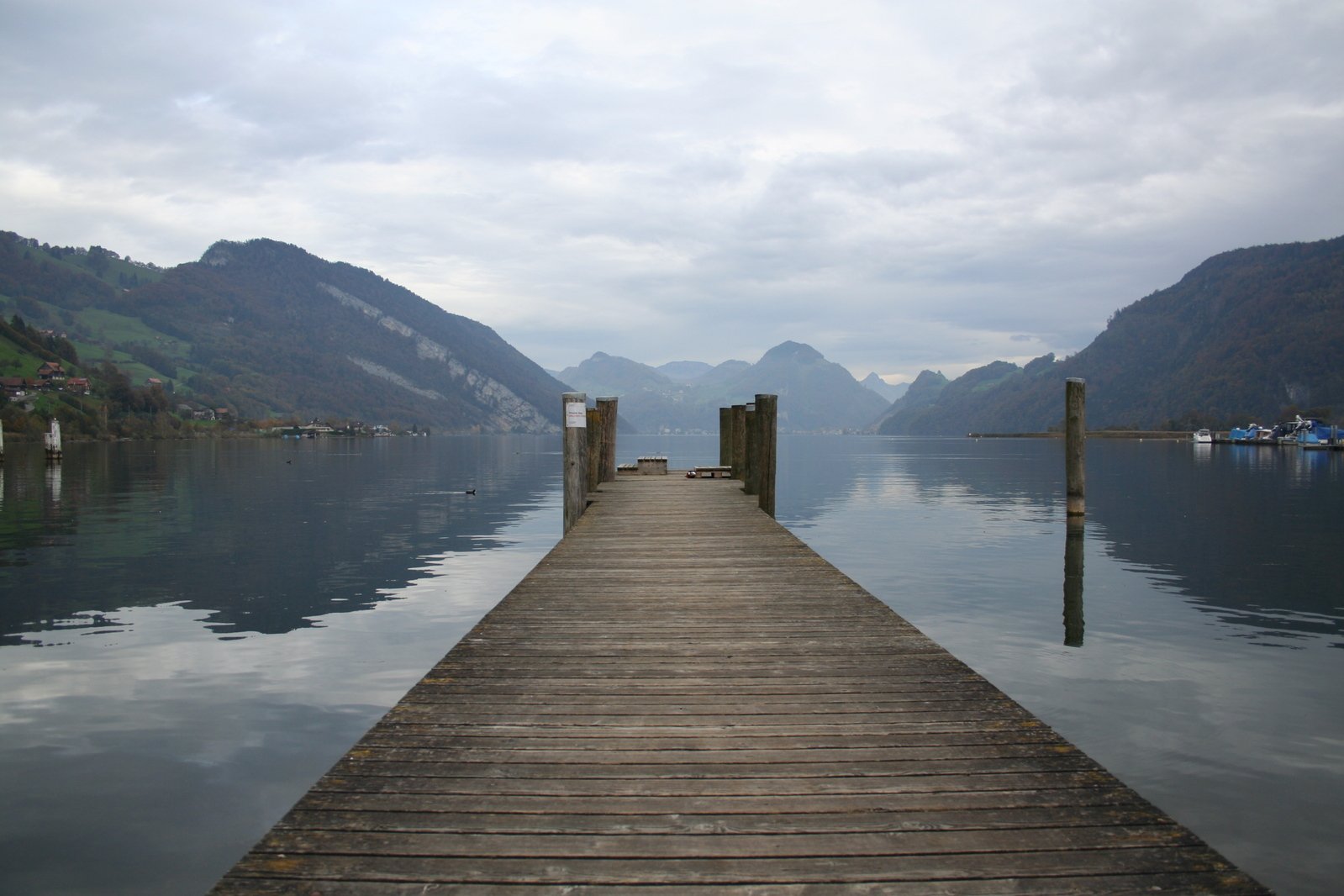 the dock extends into a lake near a mountain range