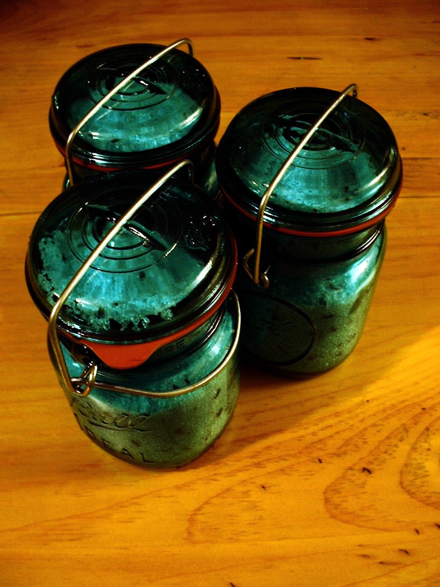 four glass jars with ropes sitting on a table