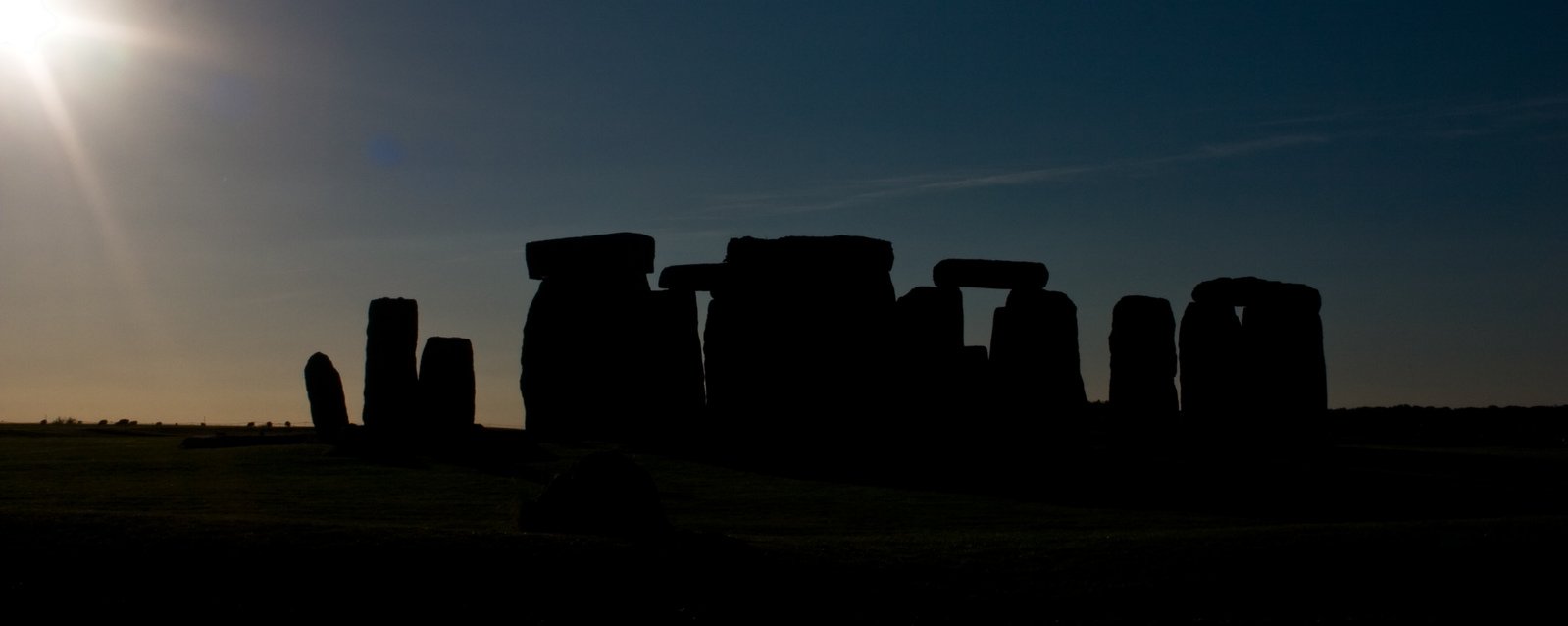 the sun is shining behind some stones