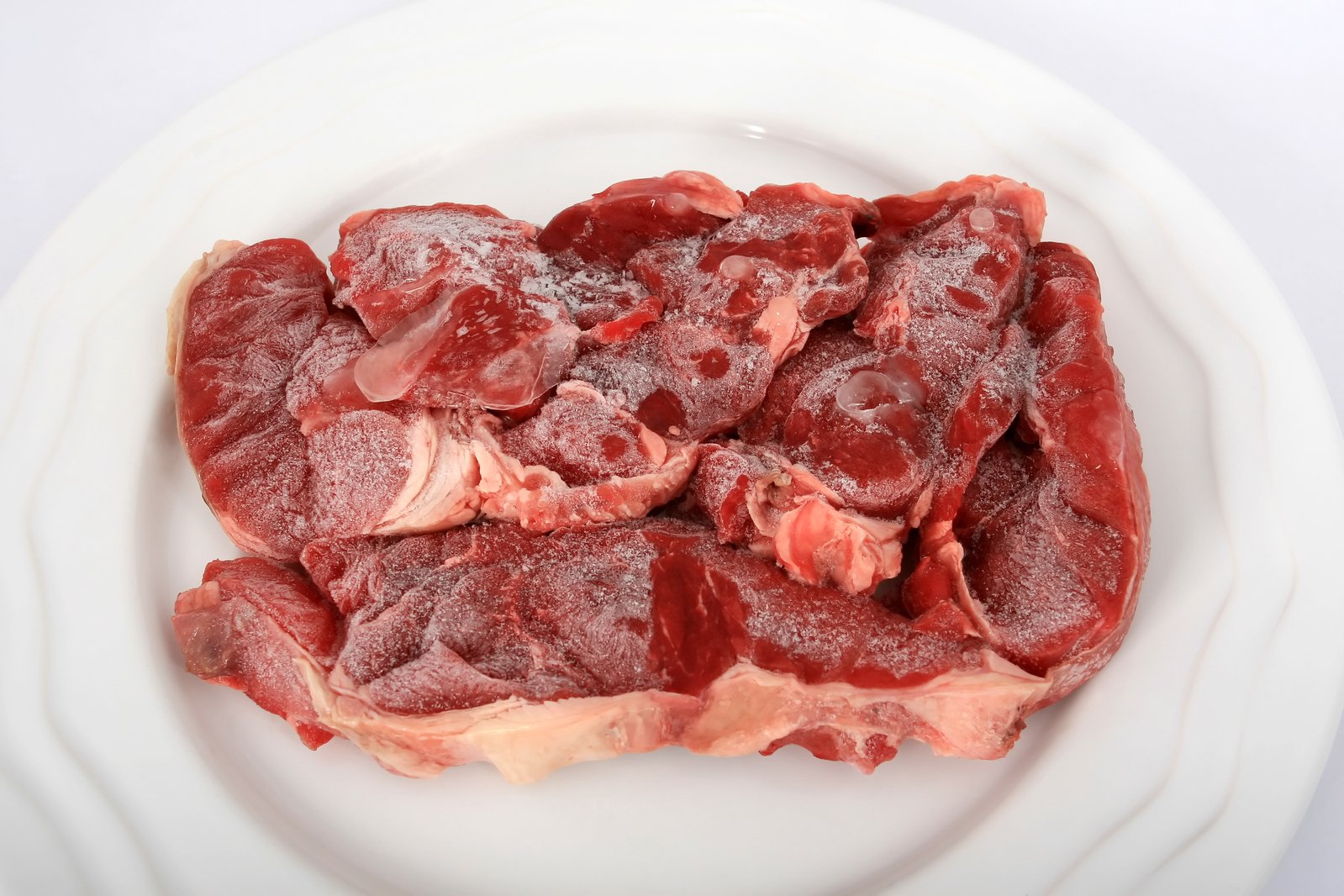 a pile of raw meat sitting on top of a white plate