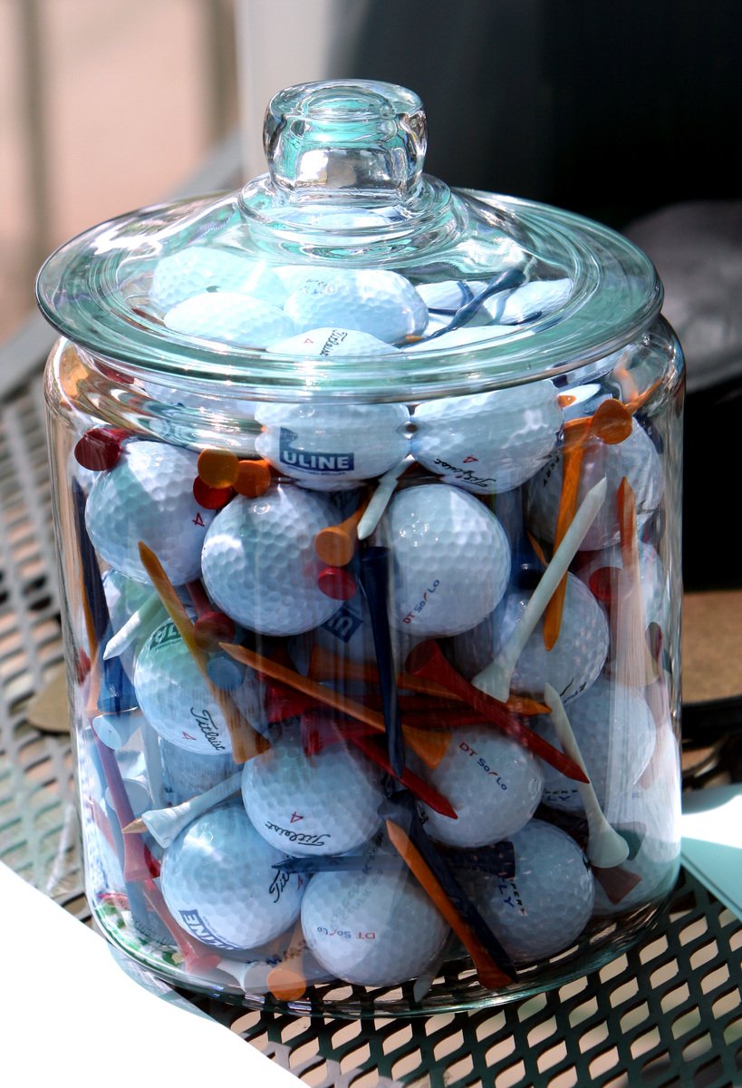 there is a jar with many golf balls in it