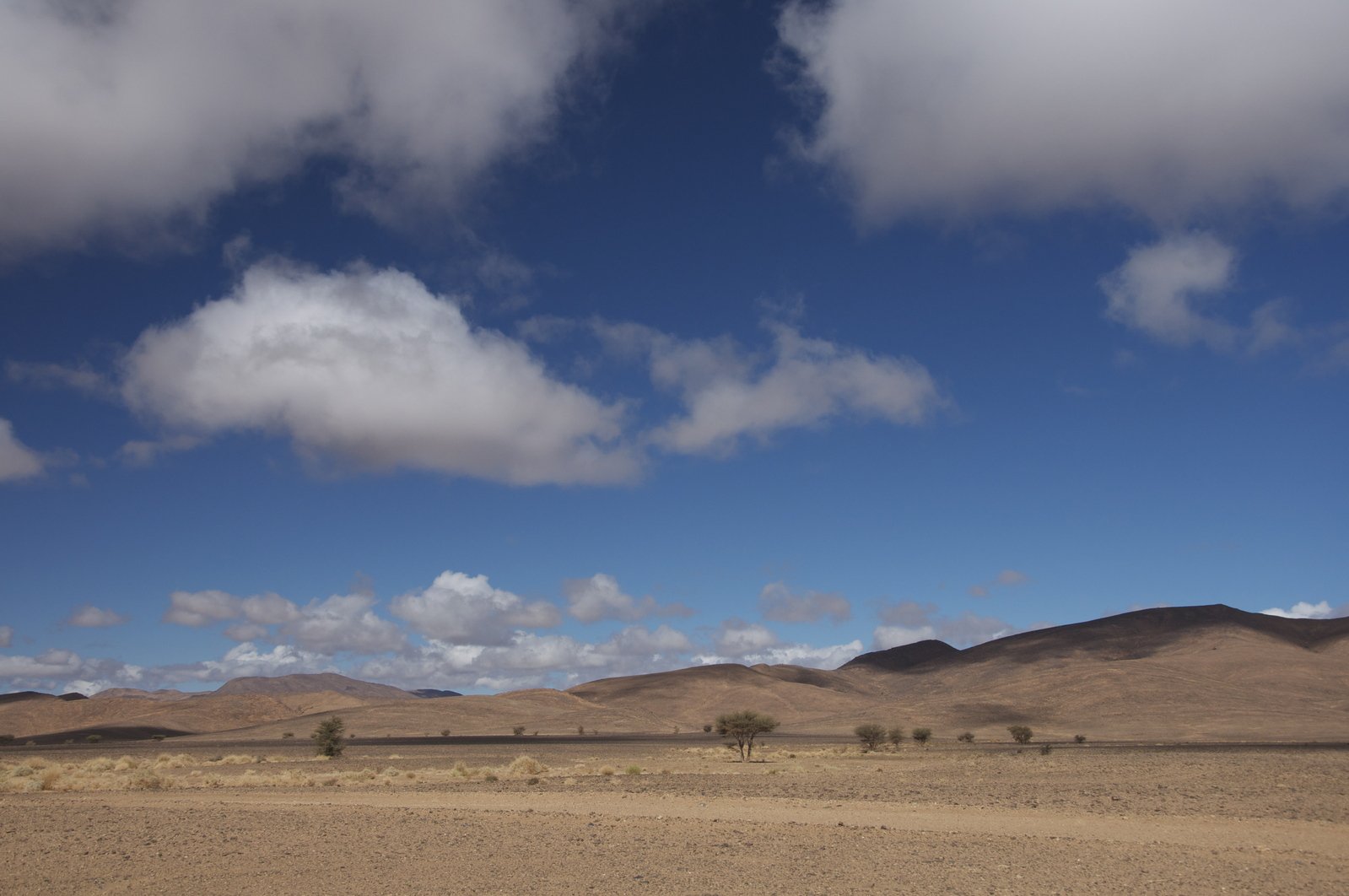 mountains with clouds over the desert in the daytime