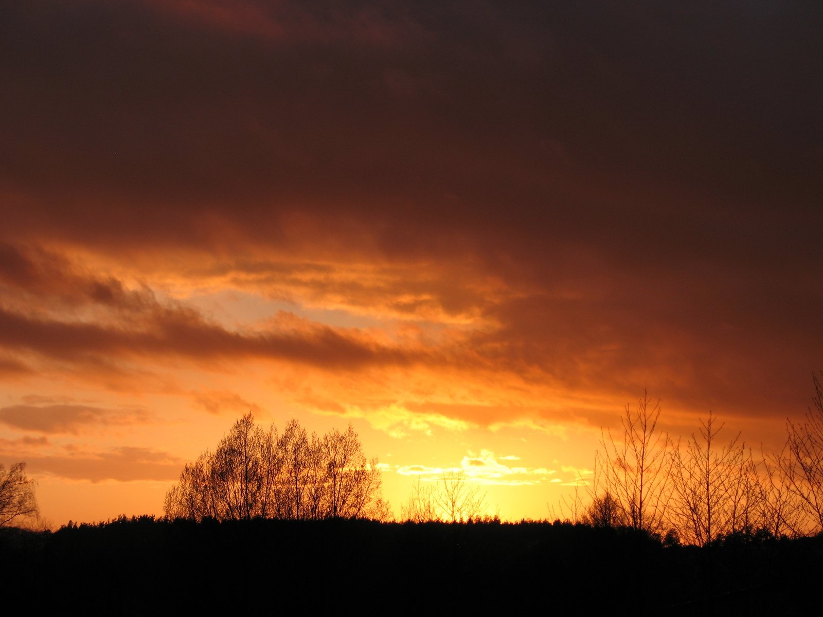 the sun is rising behind some dark clouds