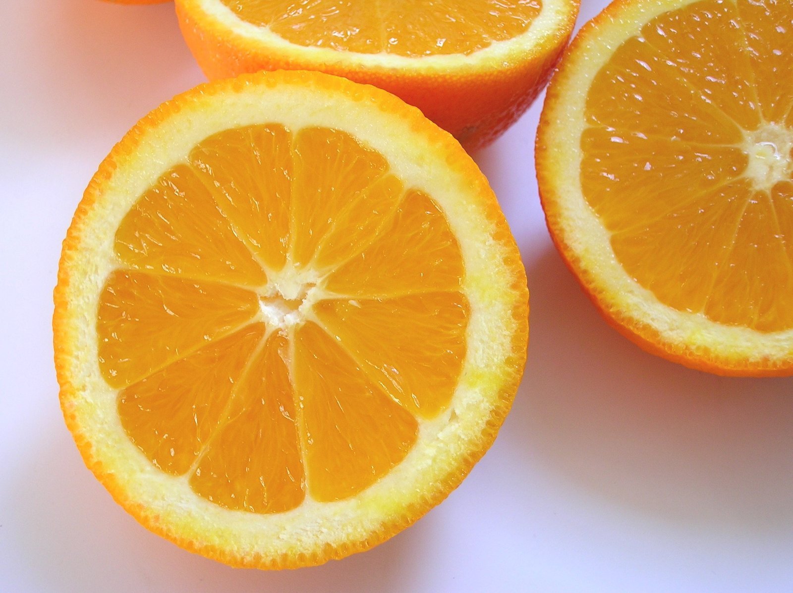 some cut oranges sitting on a table and ready to be eaten