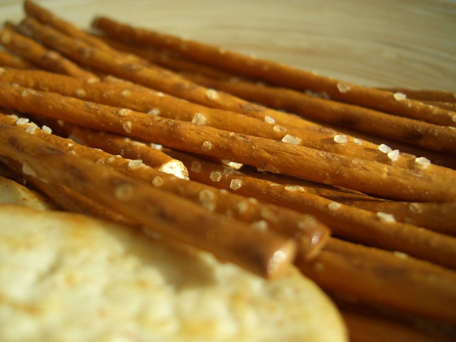 a wooden plate of dog sticks and some other snack ingredients