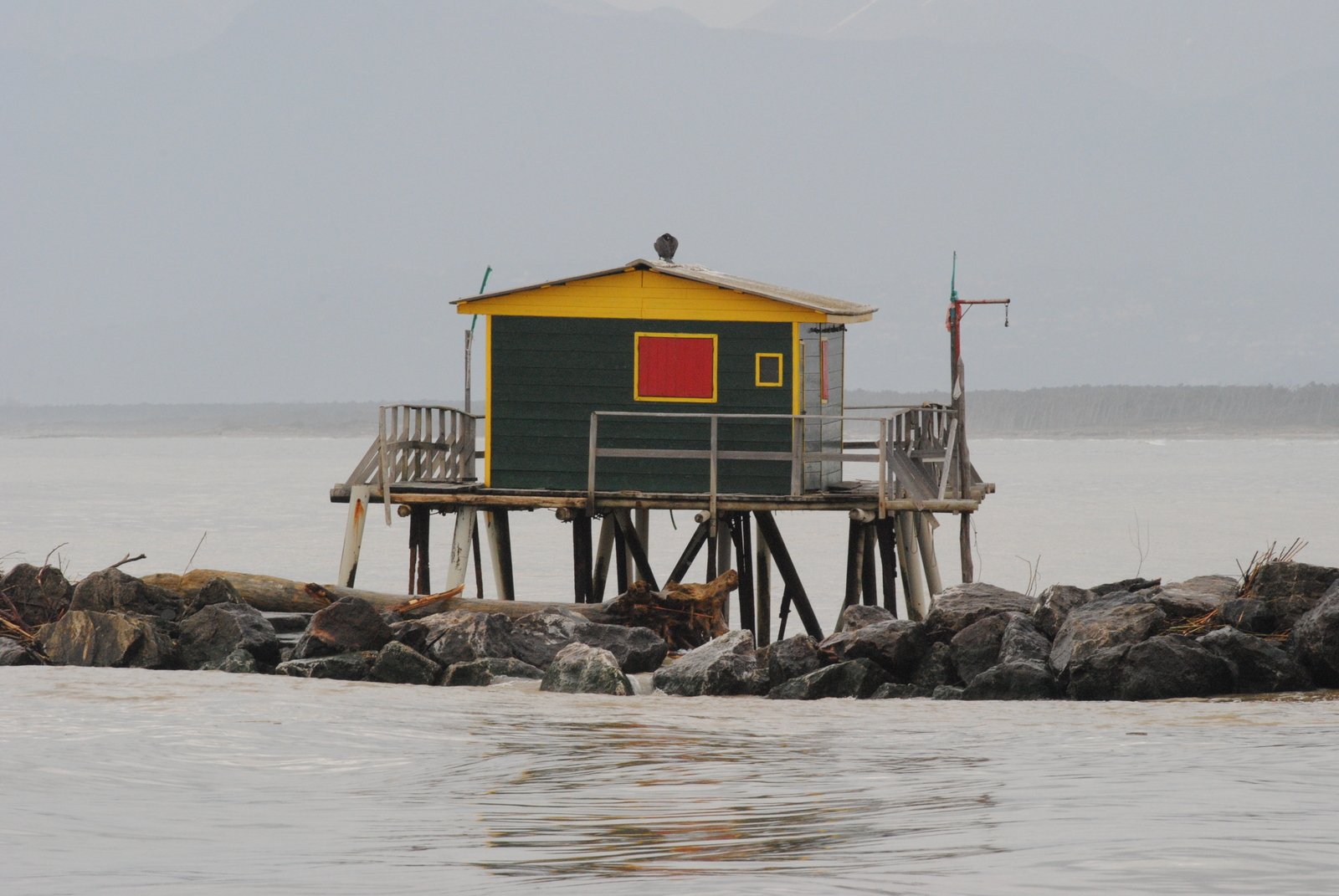 a small shack with red door near the ocean