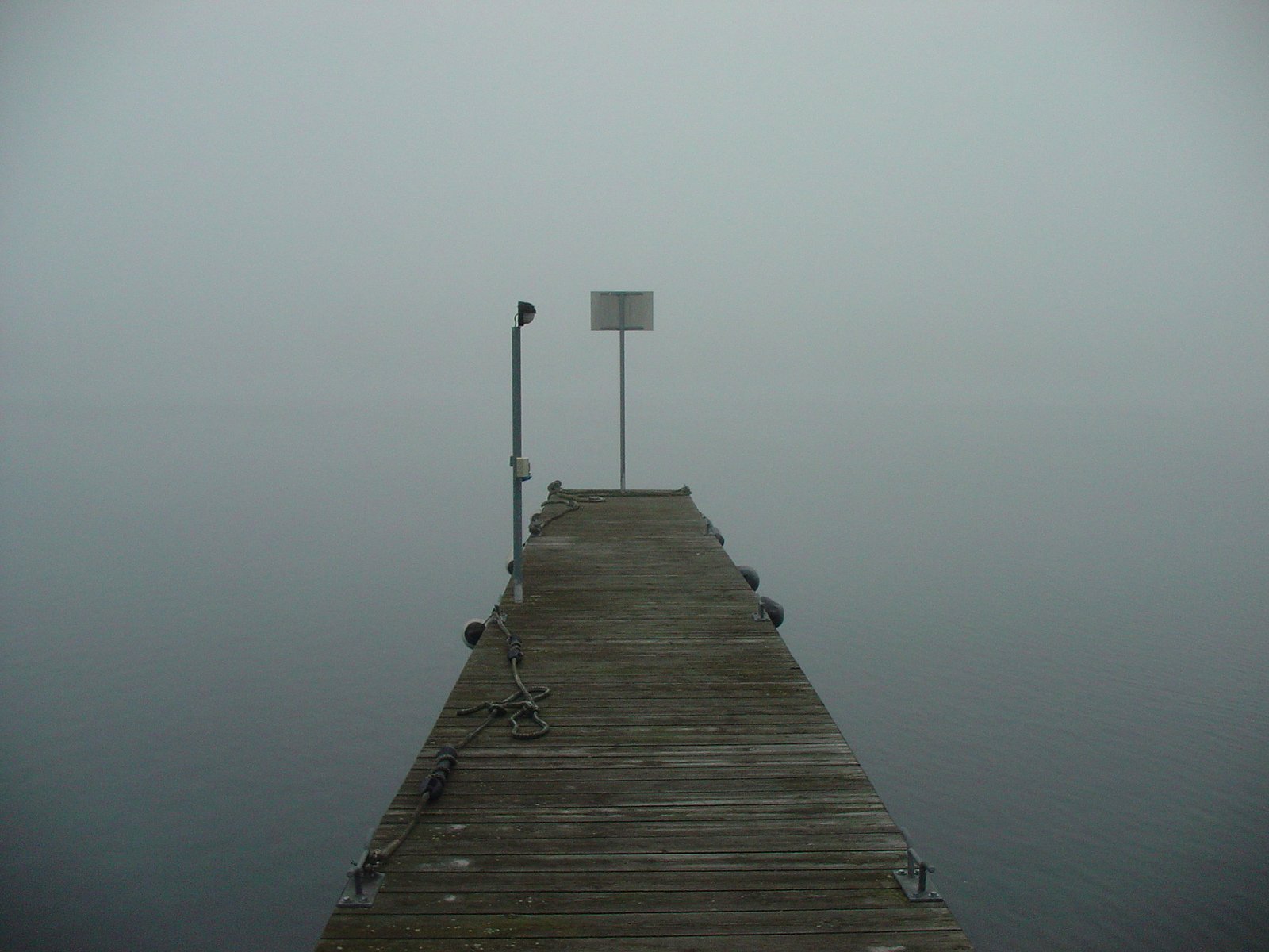 the end of the pier looks out onto the foggy water