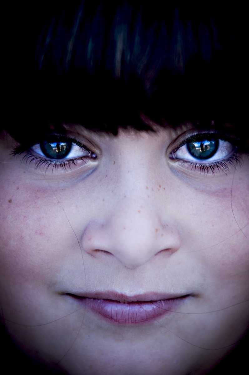 a girl with her blue eyes has freckled lashes