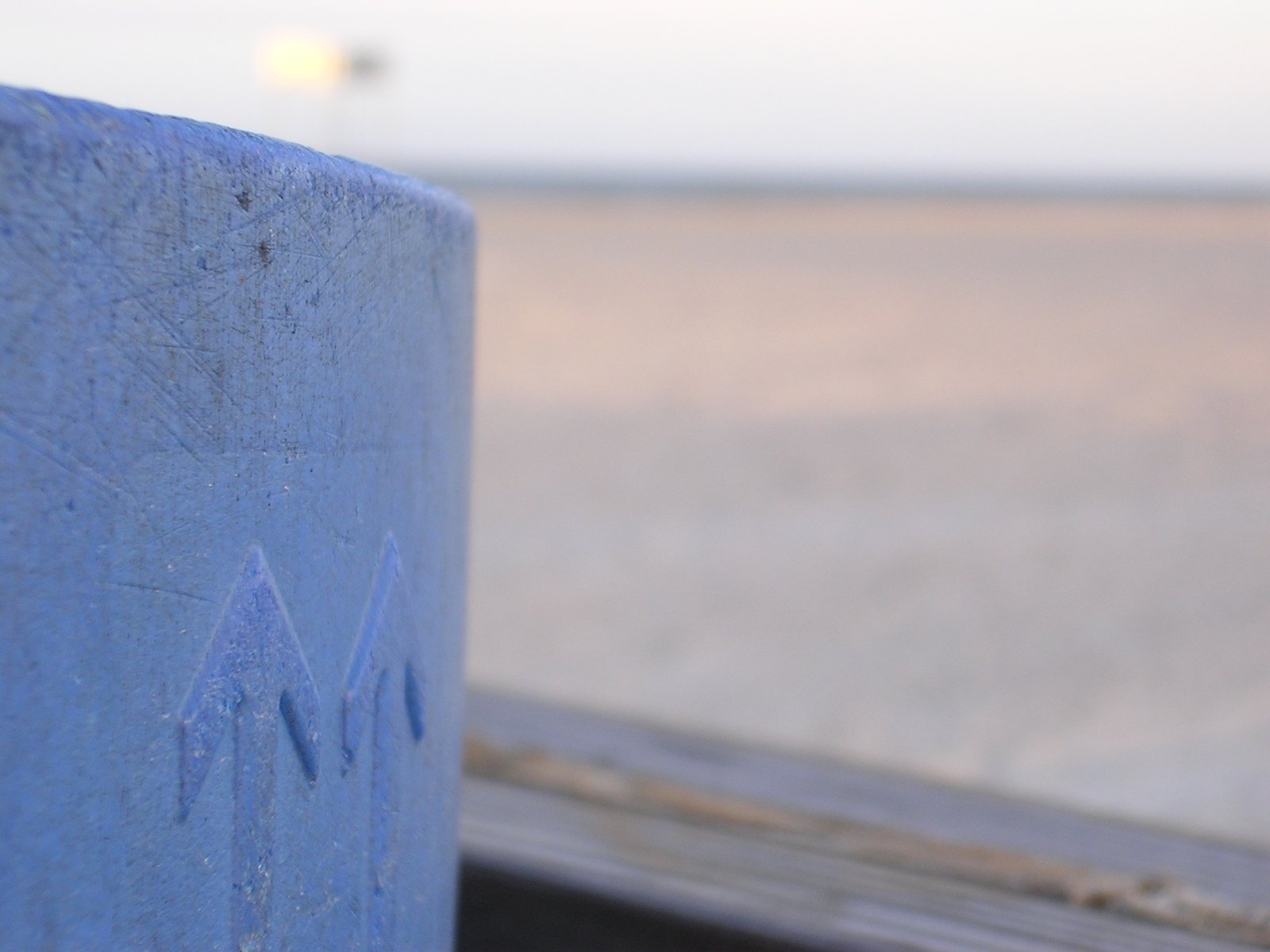 a close up view of a blue post on a wooden surface