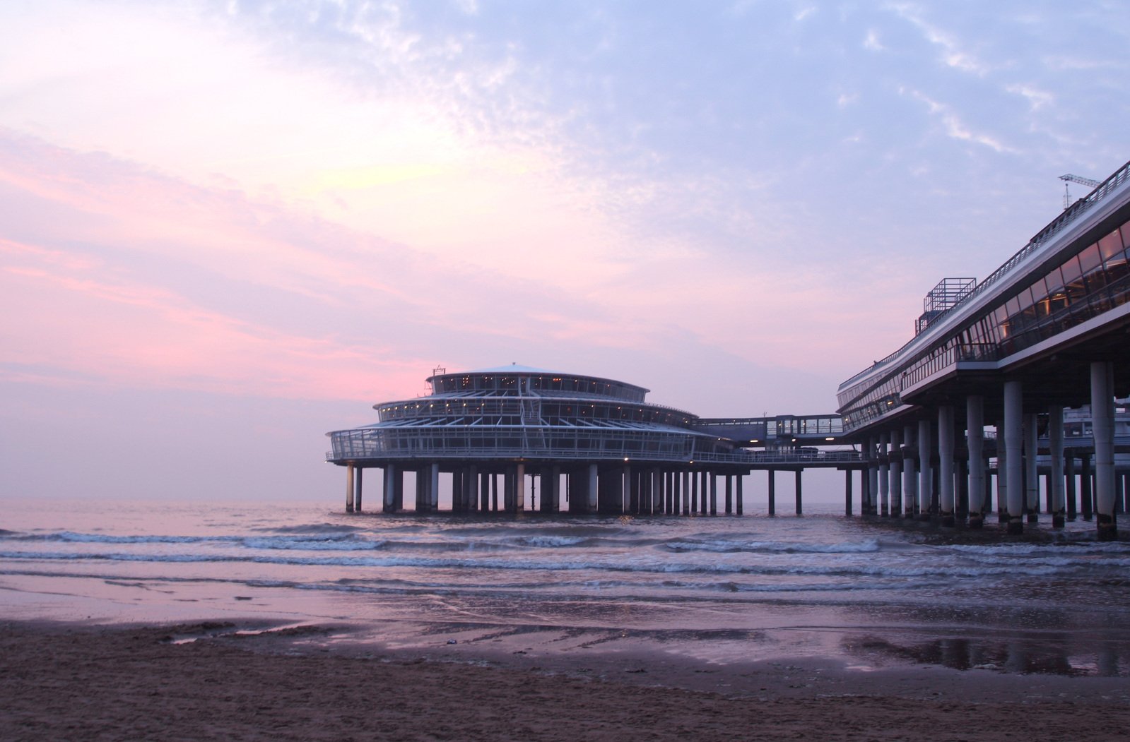 the beach has waves in it and two buildings on it