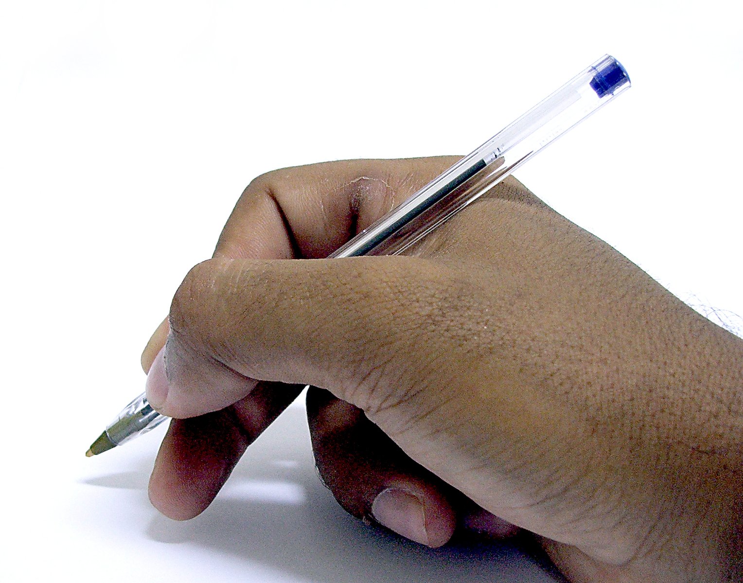 a hand with a pen in it on a table